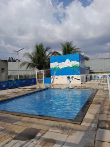 a swimming pool with a blue and white fence at Condomínio Salinas - Bella Città in Marituba
