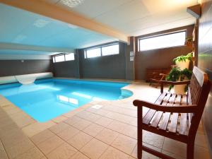 a large swimming pool in a room with a bench at Family Villa, Profondeville in Bois-de-Villers