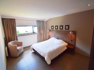 a bedroom with a bed and a chair at Family Villa, Profondeville in Bois-de-Villers