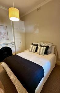 a bedroom with a large bed with two pillows at Charming Sandstone Villa in the heart of Norwood in Rose Park