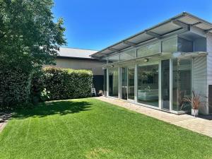 a large glass house with a lawn in front of it at Charming Sandstone Villa in the heart of Norwood in Rose Park