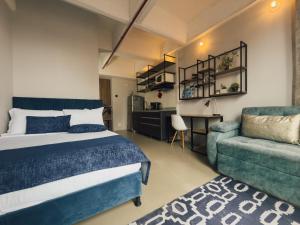 a bedroom with a bed and a couch and a chair at Apartamento Central Bogota in Bogotá