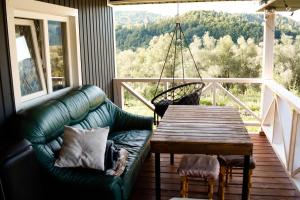 a living room with a green couch and a wooden table at Садиба Смугар in Rostoki