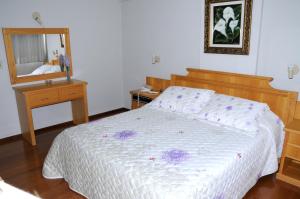 a bedroom with a bed and a mirror at Hotel Elite in Paranavaí