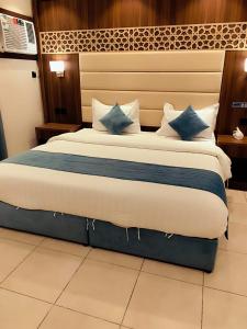 a bedroom with a large bed with blue pillows at ليالي - الربوة in Jeddah