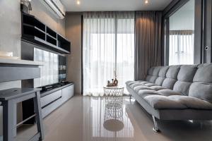 a living room with a couch and a large window at Luxury 1BR Apt Kamala Beach Resort P409 in Kamala Beach