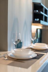 a table with two white plates and wine glasses at Luxury 1BR Apt Kamala Beach Resort B413 in Kamala Beach