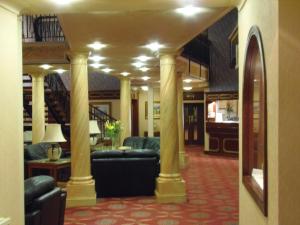 a living room with couches and tables and columns at Lakeside International Hotel in Camberley
