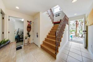 una escalera en una casa con paredes blancas en Beach Home with Amazing Oasis Pool Spa Waterfall Fire Pit Bikes, en Marineland