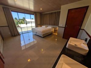 a bedroom with a bed and a bathroom with a sink at Parawing Paracuru in Paracuru