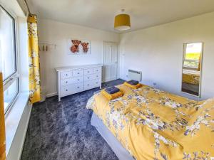una camera da letto con un letto, un comò e una finestra di Beachcroft Cottage a Aird Tong