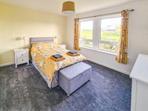 una camera da letto con un letto e una finestra di Beachcroft Cottage a Aird Tong