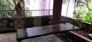 a wooden bench chained to a balcony with a window at Aara Homes White town in Puducherry