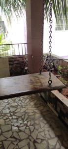 a swing in a porch with a palm tree at Aara Homes White town in Puducherry