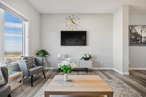 a living room with a table and a clock on the wall at Cozy 3-Bedroom Family Retreat Home in Rangeview in Calgary