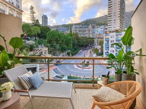 a balcony with a table and chairs and a view of a city at Fairmont Monte Carlo in Monte Carlo