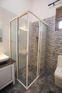 a bathroom with a glass shower with a toilet at Hotel Magdalina Lagoon in Negombo +18 photos