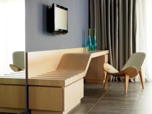 a desk in a room with a tv on a wall at Tesoro Blu Hotel & Spa Adults Only in Skala Kefalonias