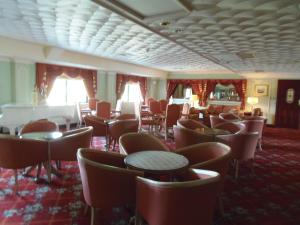 a dining room with chairs and tables in a hotel at Lakeside International Hotel in Camberley