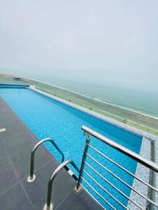 a swimming pool with the ocean in the background at San Miguel Apartment Vista Mar in Lima