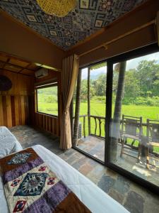 a room with a bed and a large window at Quế Homestay in Hòa Bình