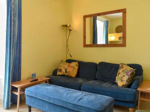 a living room with a blue couch and a mirror at St Abbs - Lighthouse Retreat in Saint Abbs