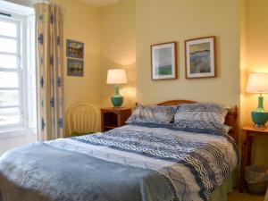 a bedroom with a bed and two lamps and a window at St Abbs - Lighthouse Retreat in Saint Abbs +20 photos
