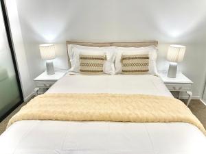 a bedroom with a large white bed with two night stands at Modern apartment in the city center in Auckland +20 photos