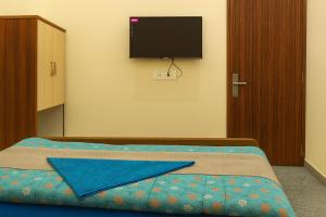 a bedroom with a bed with a flat screen tv on the wall at Vinayaka Heritage in Patna