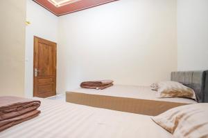 Ένα ή περισσότερα κρεβάτια σε δωμάτιο στο Omah Ati Guesthouse Syariah