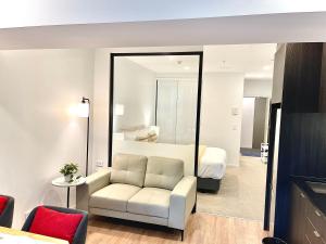 a living room with a white couch and a bedroom at Modern apartment in the city center in Auckland