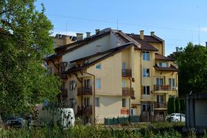 a large yellow building with a lot of windows at Velena Apartments in Kranevo