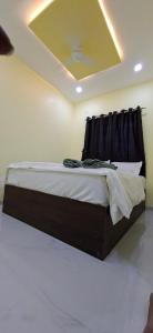 a bed in a room with a ceiling at Shreenath gurukupa bhaktnivas in Bandanwāda
