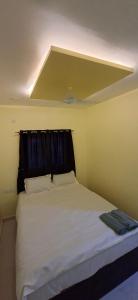 a bedroom with a large white bed with a ceiling at Shreenath gurukupa bhaktnivas in Bandanwāda