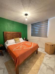a bedroom with a bed with a green wall at Casa Karantani in Pátzcuaro