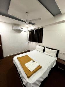 a bedroom with a bed with a towel on it at Hotel OLOTUS in Surat
