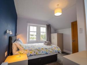 a small bedroom with a bed and a window at Crannoch Self Catering in Buckie