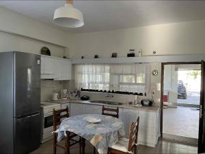 a kitchen with a table and a refrigerator at St Andrews Seafront Appartement in Agios Andreas