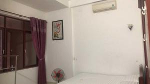 a bedroom with a bed and a window and a fan at Nhà nghỉ hảo hảo in Da Nang
