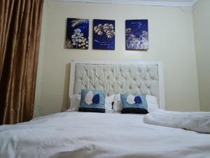a bedroom with a large white bed with pillows at Blissful abode in Kisumu