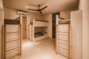 a room with three bunk beds and a ceiling at Kavo Maison Surf & Yoga Camp in Munggu