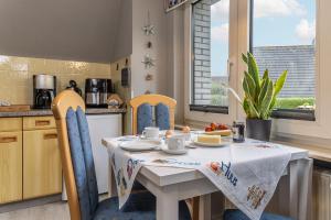 カロリーネンジールにあるFerienwohnung KUMM RIN - Oase an der Nordseeのキッチン(白いテーブル、椅子、テーブル、椅子付)
