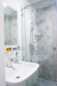 une salle de bain avec un lavabo et une douche en verre dans l'établissement Air Plaza, à Samarcande