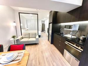a living room with a couch and a table in a room at Modern apartment in the city center in Auckland