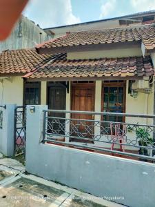 a small house with a gate and a balcony at Abadi Kos Harian in Ngabean +3 photos