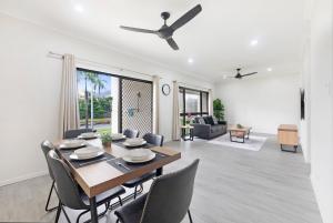 a dining room and living room with a table and chairs at Zen Coastal Hideaway 2BR Modern - Hospital - Beach in Casuarina