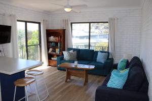 a living room with a blue couch and a table at Doc's Place at Crescent Head in Crescent Head