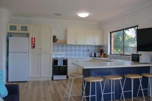 a kitchen with a counter and stools in it at Doc's Place at Crescent Head in Crescent Head