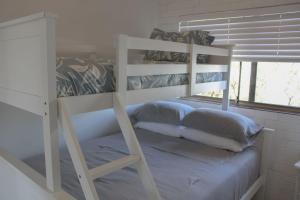a bedroom with a bunk bed with a ladder at Doc's Place at Crescent Head in Crescent Head