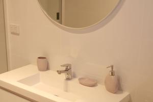 a white bathroom with a sink and a mirror at Doc's Place at Crescent Head in Crescent Head +14 photos